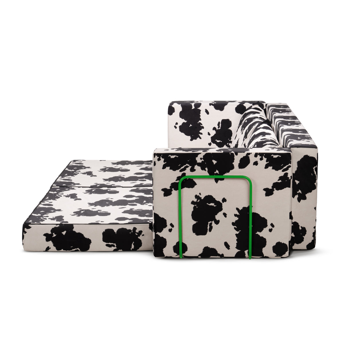 Flow Cow sofa bed in black-and-white cow print fabric with a green metal frame, with one mattress unfolded into a 100 × 170 cm single bed
