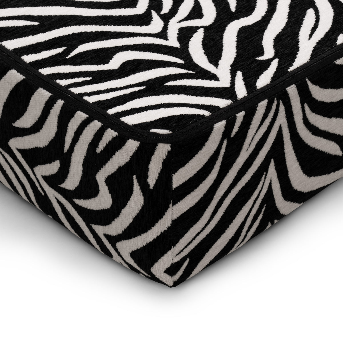 Flow Zebra sovesofa i sort-hvidt zebramønster med rødt metalstel, nærbillede af sædehyndens kant
