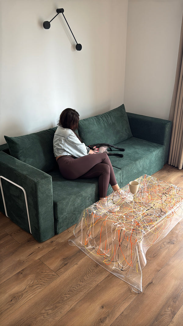Woman sitting on a dark green Flow sofa bed