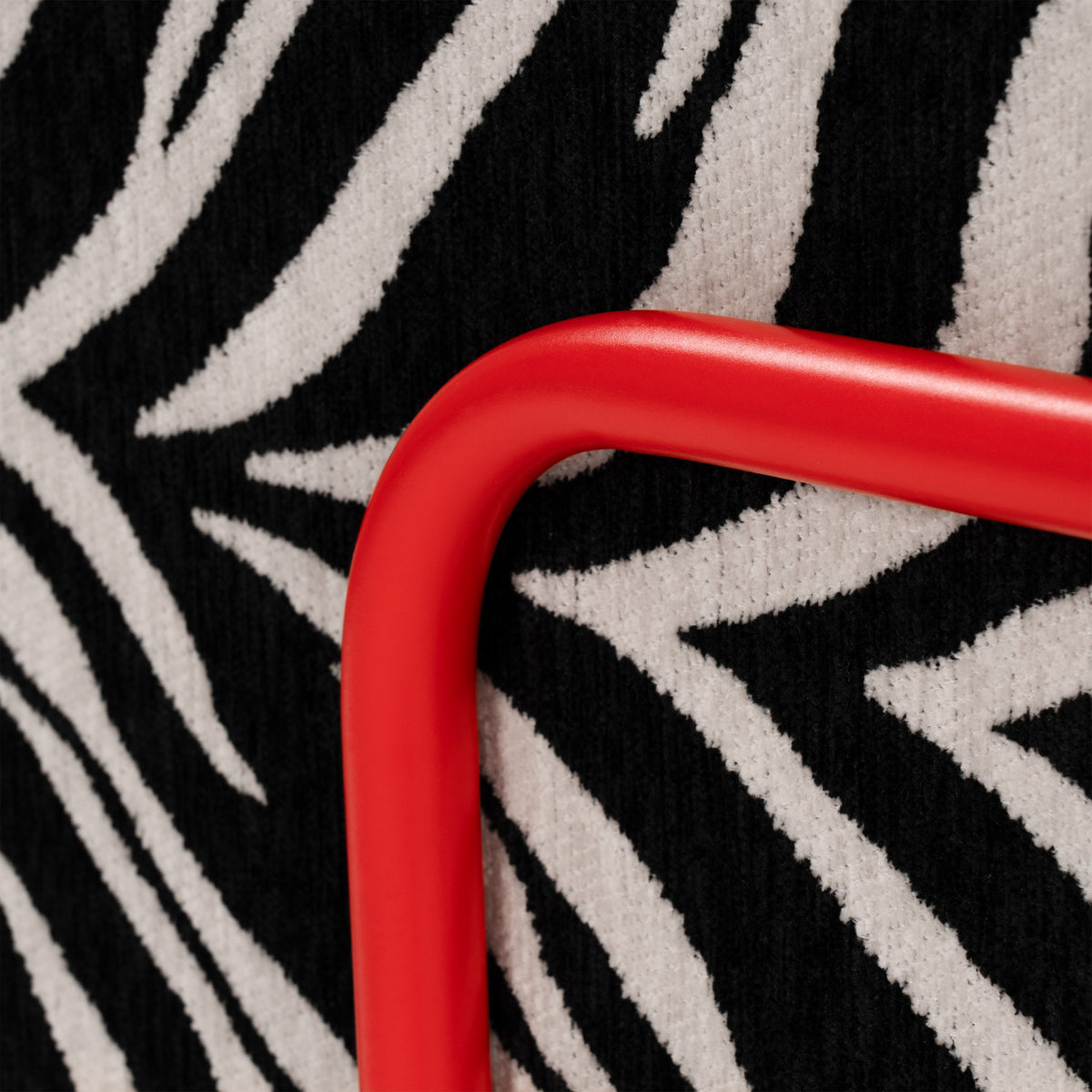 Flow Zebra sovesofa i sort-hvidt zebramønster med rødt metalstel, nærbillede af metalstellet