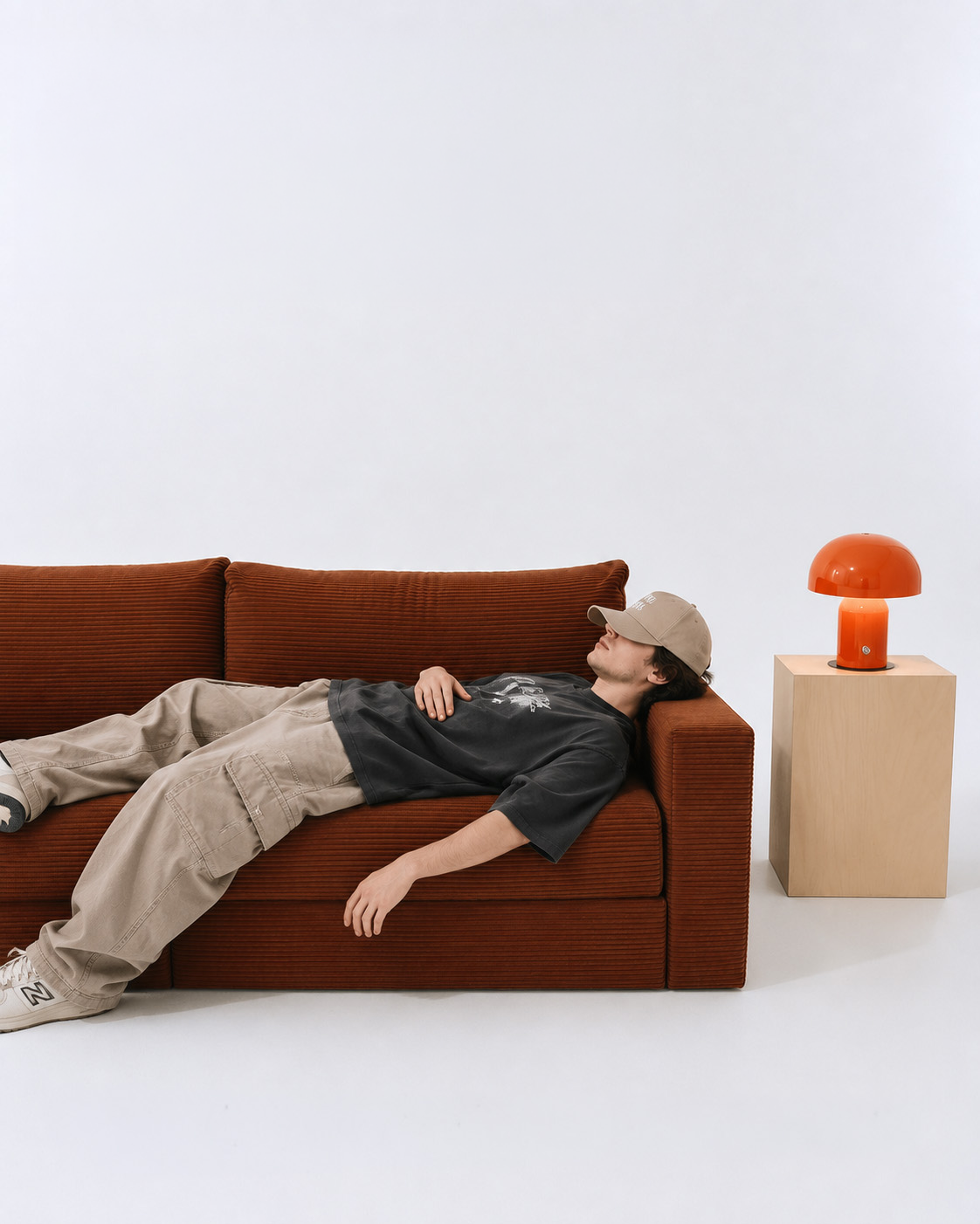 Man resting on a rust brown Flow sofa bed