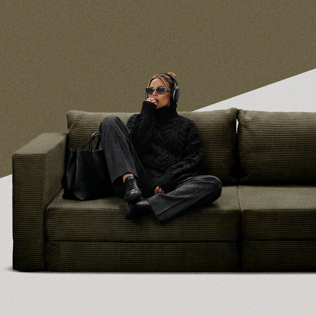 Woman relaxing on an olive green Flow sofa bed